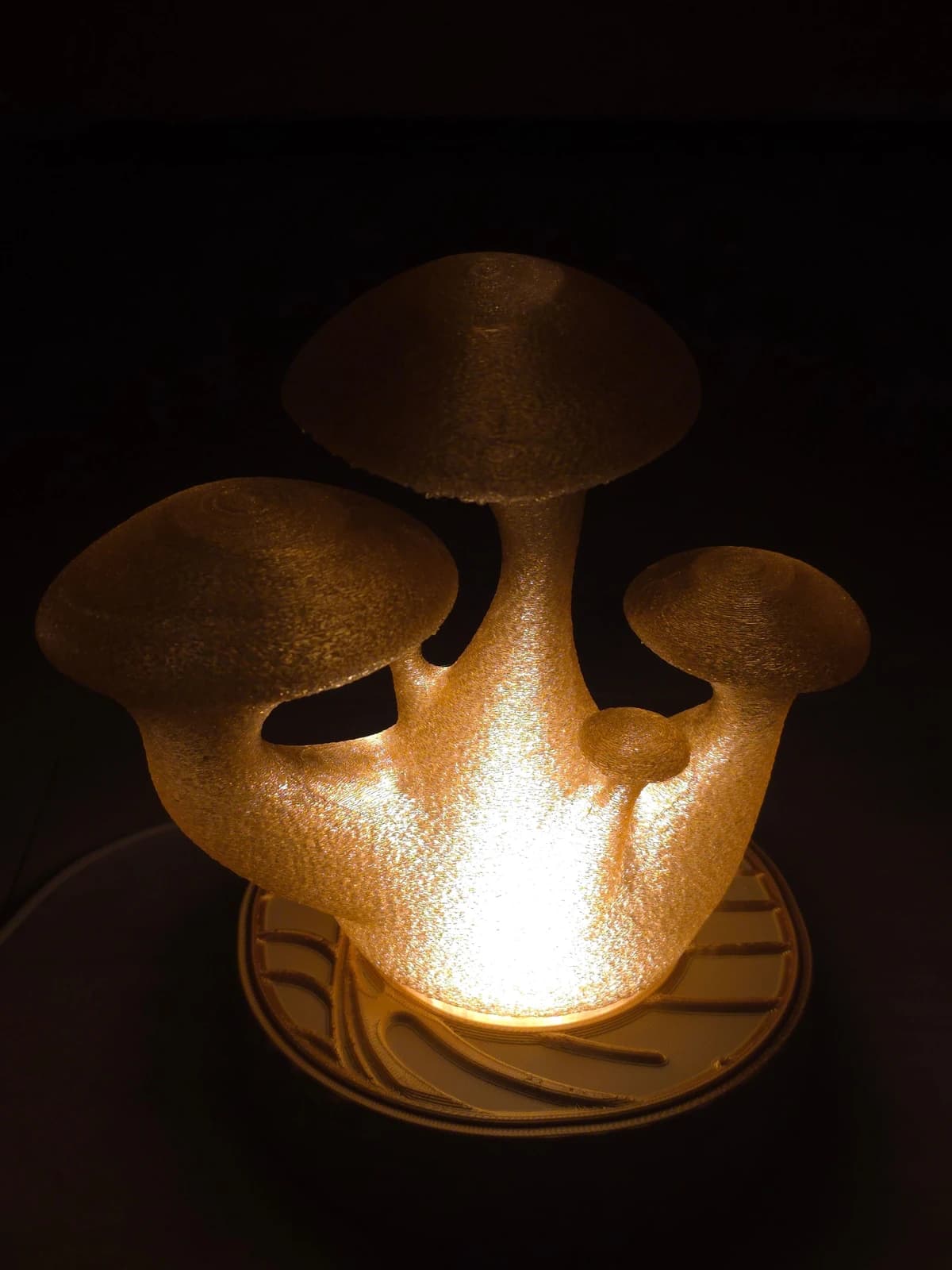 Ta sama lampa włączona w ciemności — grzybki świecą ciepłym złotem